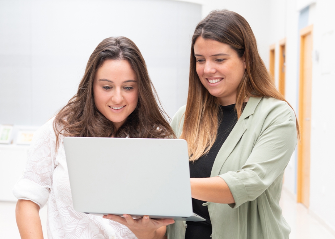 smilling-females-studying-computer-screen